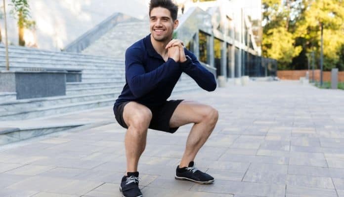 Man doing squat exercise to reduce delayed onset muscle soreness